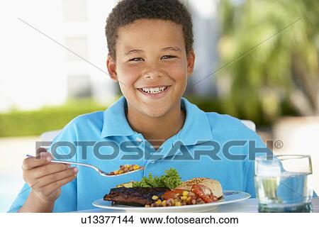 Picture - Young Boy Dining Al Fresco. Fotosearch