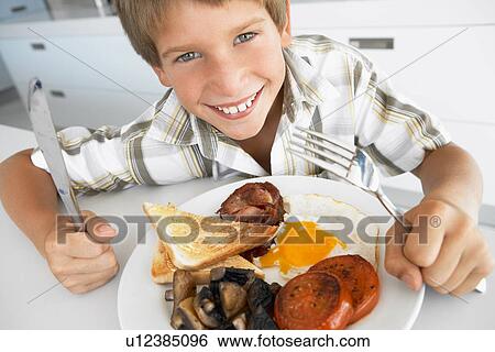 Stock Photograph - Young Boy Eating Unhealthy Fried Breakfast. Fotosearch