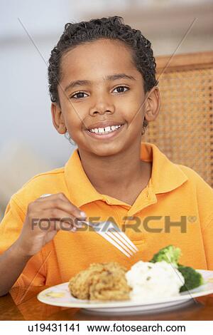 Young Boy Enjoying A Meal At Home View Large Photo Image Stock Image - Young Boy Enjoying A Meal At Home. Fotosearch