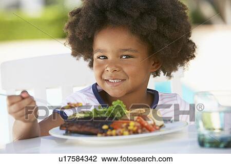 Stock Image - Young Girl Dining Al Fresco. Fotosearch