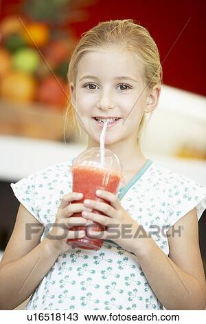 Stock Image - Young Girl Drinking A Berry Smoothie. Fotosearch