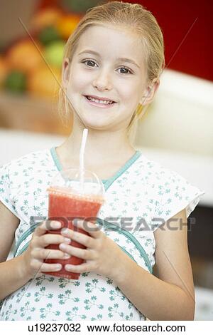 Stock Image - Young Girl Drinking A Berry Smoothie. Fotosearch
