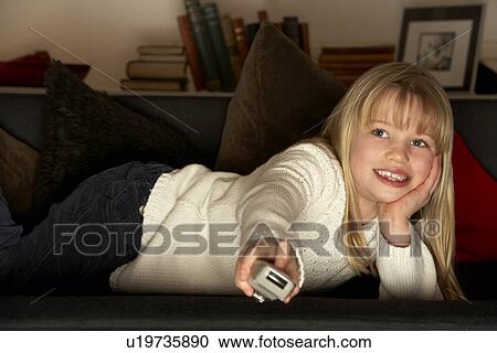 Stock Image - Young Girl Using Television Remote Control. Fotosearch