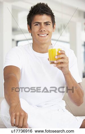 Stock Photograph - Young Man Drinking Orange Juice. Fotosearch