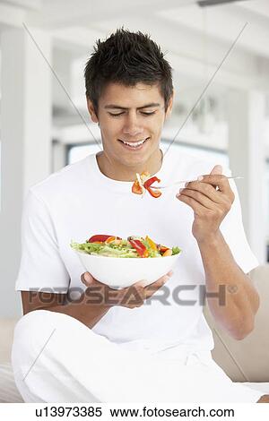 Stock Photography - Young Man Eating A Salad. Fotosearch