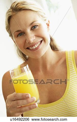 Stock Photograph - Young Woman Drinking Orange Juice. Fotosearch