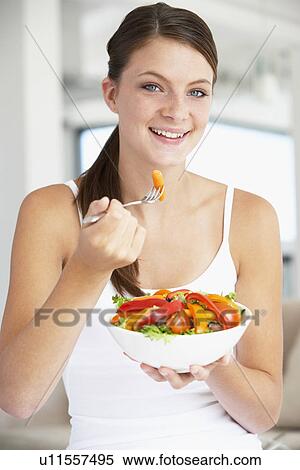 Stock Photography - Young Woman Eating A Healthy Salad. Fotosearch