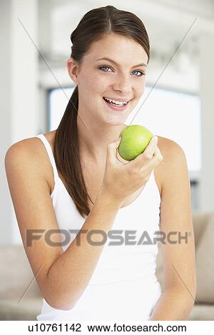 Stock Image - Young Woman Eating An Apple. Fotosearch