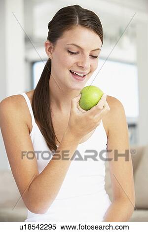 Stock Photography - Young Woman Eating An Apple. Fotosearch