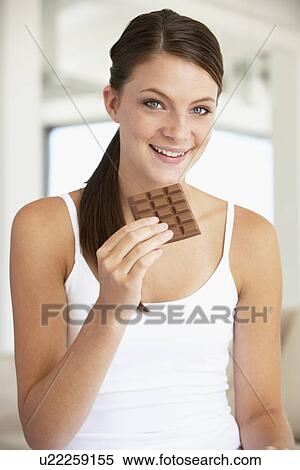 Stock Photography - Young Woman Eating Chocolate. Fotosearch