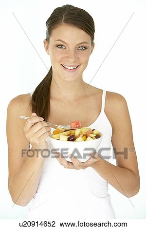 Stock Image - Young Woman Eating Fresh Fruit Salad. Fotosearch