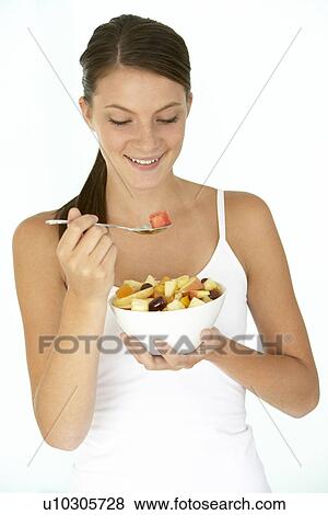 Stock Photo - Young Woman Eating Fresh Fruit Salad. Fotosearch