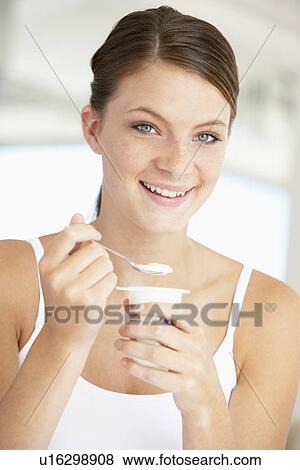 Young Woman Eating Yogurt View Large Photo Image Stock Photo - Young Woman Eating Yogurt. Fotosearch