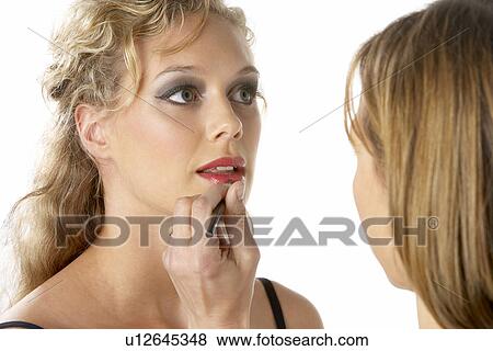 Stock Photo - Young Woman Having Her Lipstick Applied. Fotosearch