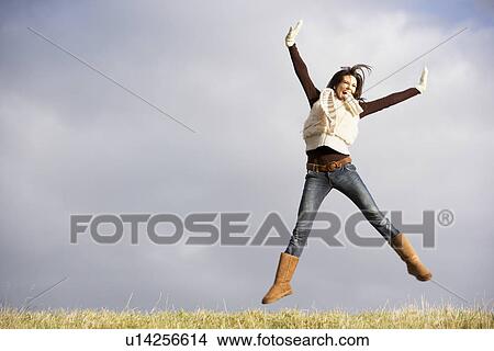 Picture - Young Woman Jumping In Air. Fotosearch
