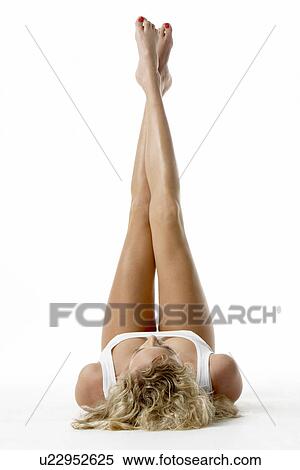 Stock Photography - Young Woman Lying Down With Her Legs In The Air. Fotosearch