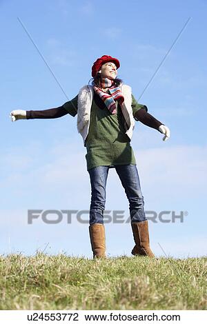 Stock Image - Young Woman Standing In Park. Fotosearch