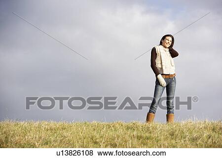 Stock Photo - Young Woman Standing In Park. Fotosearch