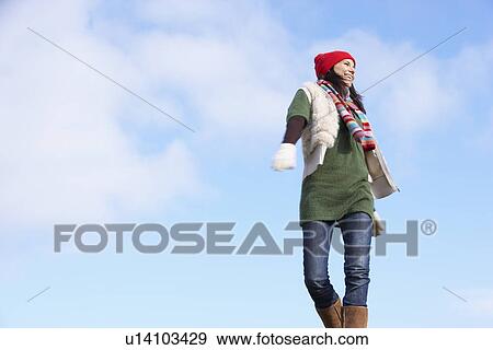 Stock Photo - Young Woman Standing In Park. Fotosearch