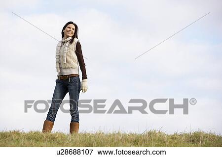 Stock Photo - Young Woman Standing In Park. Fotosearch