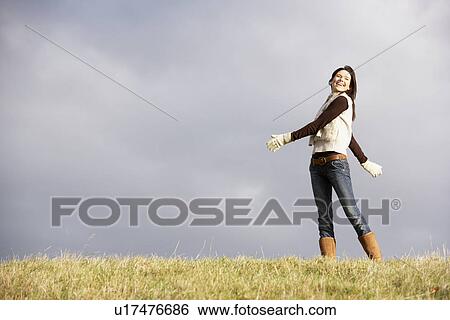 Stock Photograph - Young Woman Standing In Park. Fotosearch