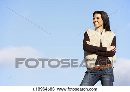 Stock Image - Young Woman Standing In The Park. Fotosearch