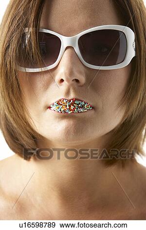 Stock Photo - Young Woman Wearing Sunglasses With Sprinkles On Her Lips. Fotosearch