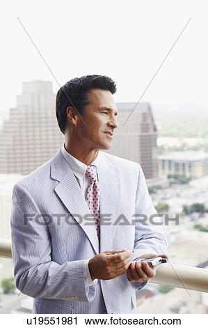 Close-up of a businessman holding a personal data assistant View Large Photo Image Stock Image - Close-up of a businessman holding a personal data assistant. Fotosearch