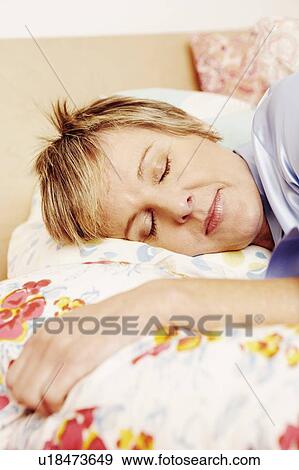 Close-up of a mature woman sleeping on the bed View Large Photo Image Stock Photo - Close-up of a mature woman sleeping on the bed. Fotosearch