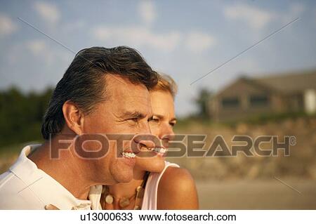Stock Image - Close-up of a mid adult woman and a mature man smiling. Fotosearch