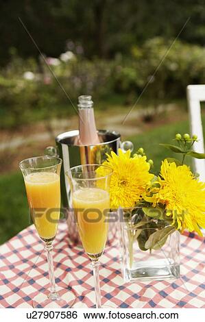 Close-up of two glasses of juice with a flower vase and an ice bucket on the table View Large Photo Image Stock Photograph - Close-up of two glasses of juice with a flower vase and an ice bucket on the table. Fotosearch