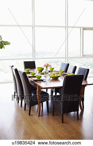 Dining table with empty chairs in a dining room View Large Photo Image Picture - Dining table with empty chairs in a dining room. Fotosearch