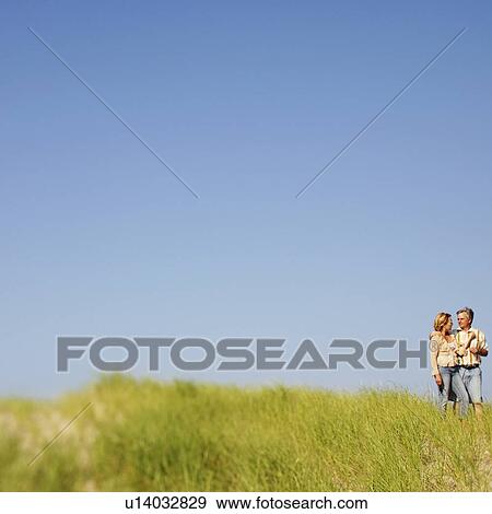 Mature couple standing on the beach View Large Photo Image Stock Photo - Mature couple standing on the beach. Fotosearch