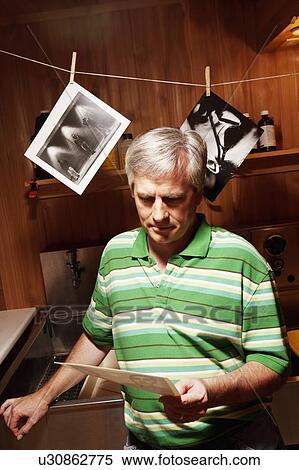 Mature man holding a photograph View Large Photo Image Stock Photography - Mature man holding a photograph. Fotosearch