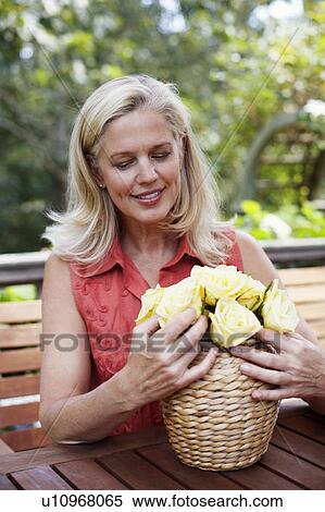Mature woman arranging flowers in a vase View Large Photo Image Stock Photography - Mature woman arranging flowers in a vase. Fotosearch