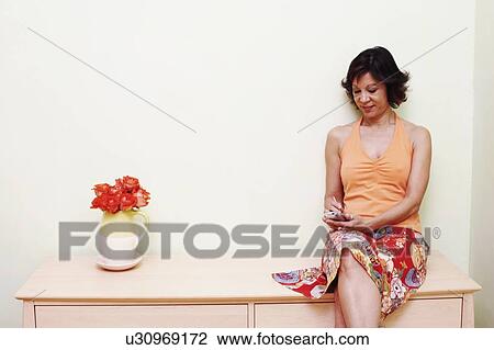 Mature woman operating a personal data assistant View Large Photo Image Stock Image - Mature woman operating a personal data assistant. Fotosearch