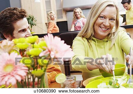 Stock Image - Portrait of a mature couple sitting at the dining table. Fotosearch