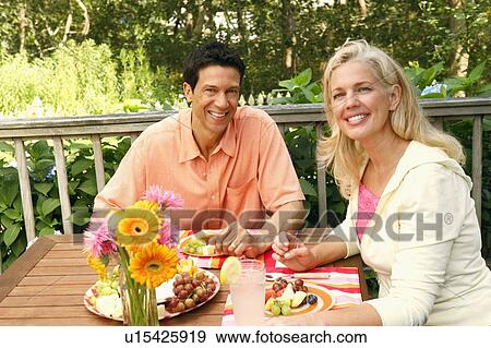 Stock Photo - Portrait of a mature couple sitting at the table. Fotosearch