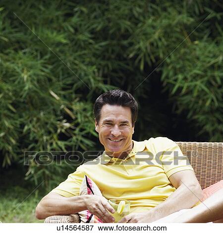 Portrait of a mature man holding a glass of lemonade View Large Photo Image Stock Photo - Portrait of a mature man holding a glass of lemonade. Fotosearch