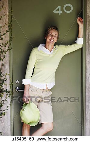 Portrait of a mature woman leaning against a door and smiling View Large Photo Image Stock Photo - Portrait of a mature woman leaning against a door and smiling. Fotosearch
