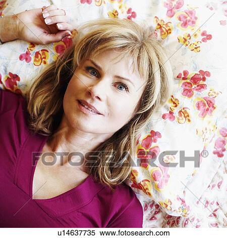 Portrait of a mature woman lying on the bed View Large Photo Image Stock Photography - Portrait of a mature woman lying on the bed. Fotosearch