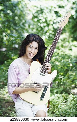 Portrait of a mature woman playing the guitar View Large Photo Image Stock Image - Portrait of a mature woman playing the guitar. Fotosearch