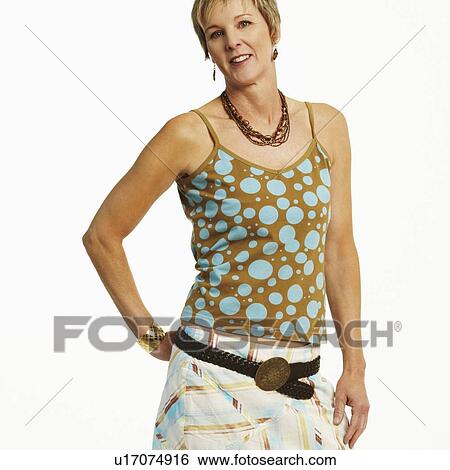 Portrait of a mature woman standing with her hand behind her back View Large Photo Image Stock Photograph - Portrait of a mature woman standing with her hand behind her back. Fotosearch