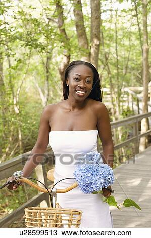 Portrait of a mid adult woman standing with a bicycle View Large Photo Image Stock Image - Portrait of a mid adult woman standing with a bicycle. Fotosearch
