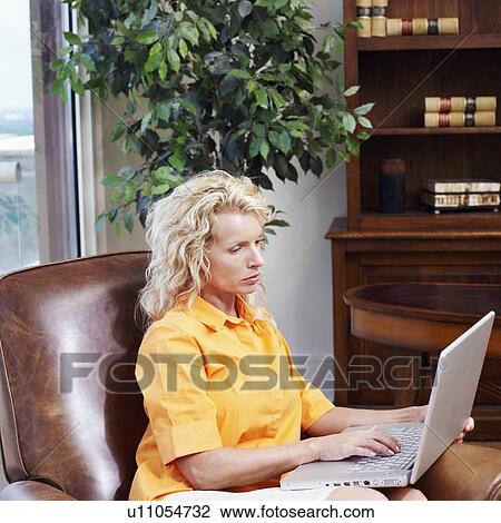 Stock Image - Side profile of a businesswoman using a laptop. Fotosearch