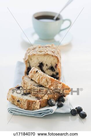 Stock Image - Blueberry cake with coffee cup in background. Fotosearch