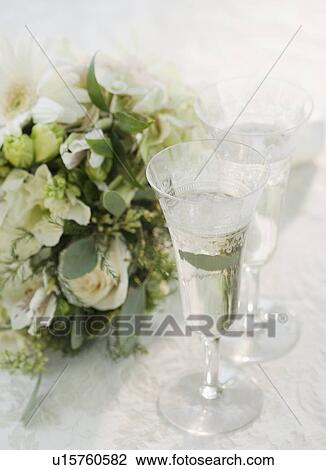 Stock Image - "Bouquet of flowers by champagne, studio shot". Fotosearch