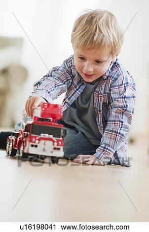 Boy (3-4) playing with toy fire engine View Large Photo Image Stock Image - Boy (3-4) playing with toy fire engine. Fotosearch