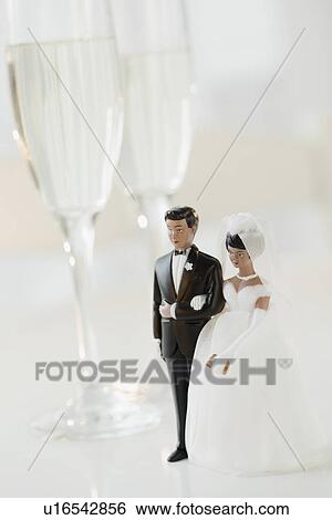 Stock Photograph - Bride and groom cake toppers by champagne glasses. Fotosearch