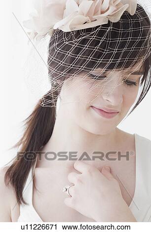 Stock Image - "Bride wearing wedding dress with veil, studio shot". Fotosearch